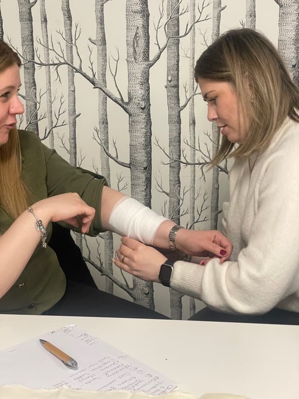 One delegate bandaging another delegate's arm
